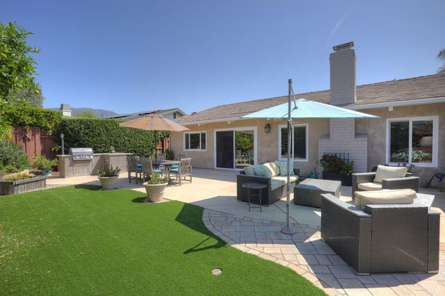 a view of a house with backyard sitting area and swimming pool