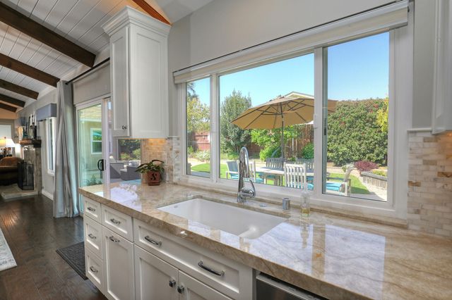 a kitchen with kitchen island a large window in it