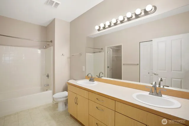 a bathroom with a double vanity sink mirror double and bathtub