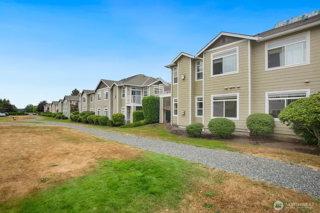 a view of a big house with a big yard and large trees