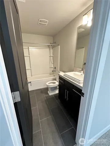 a bathroom with a sink a toilet and a mirror