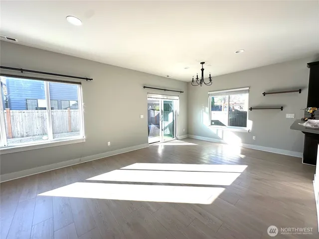 an empty room with windows and ceiling fan