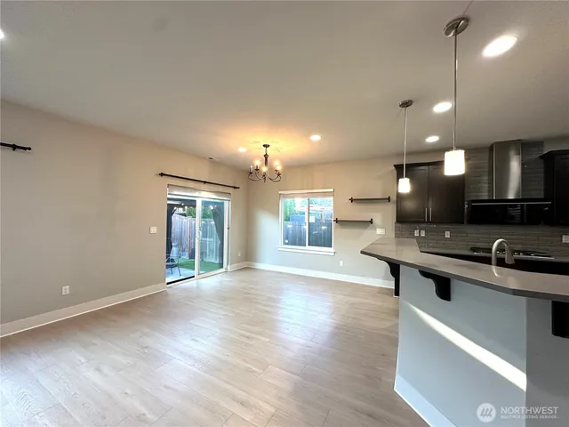 a kitchen with stainless steel appliances granite countertop a sink a stove and a wooden floors