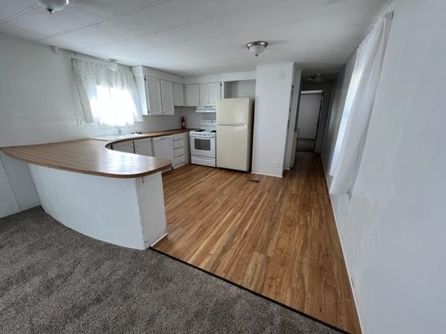 3349 F Road, Unit 14 Clifton, CO 81520 - Photo 6 of 10 a kitchen with wooden floors and refrigerator