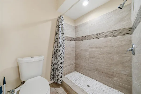 a bathroom with a toilet a sink and shower