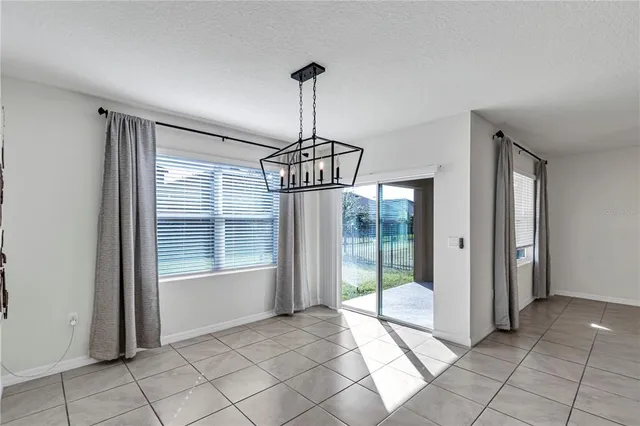 a view of a room with a chandelier and glass door