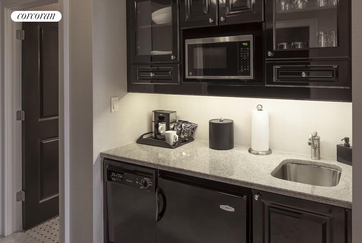 200 West 56th Street, Unit 904 Manhattan, NY 10019 - Photo 3 of 15 a kitchen with a sink and microwave