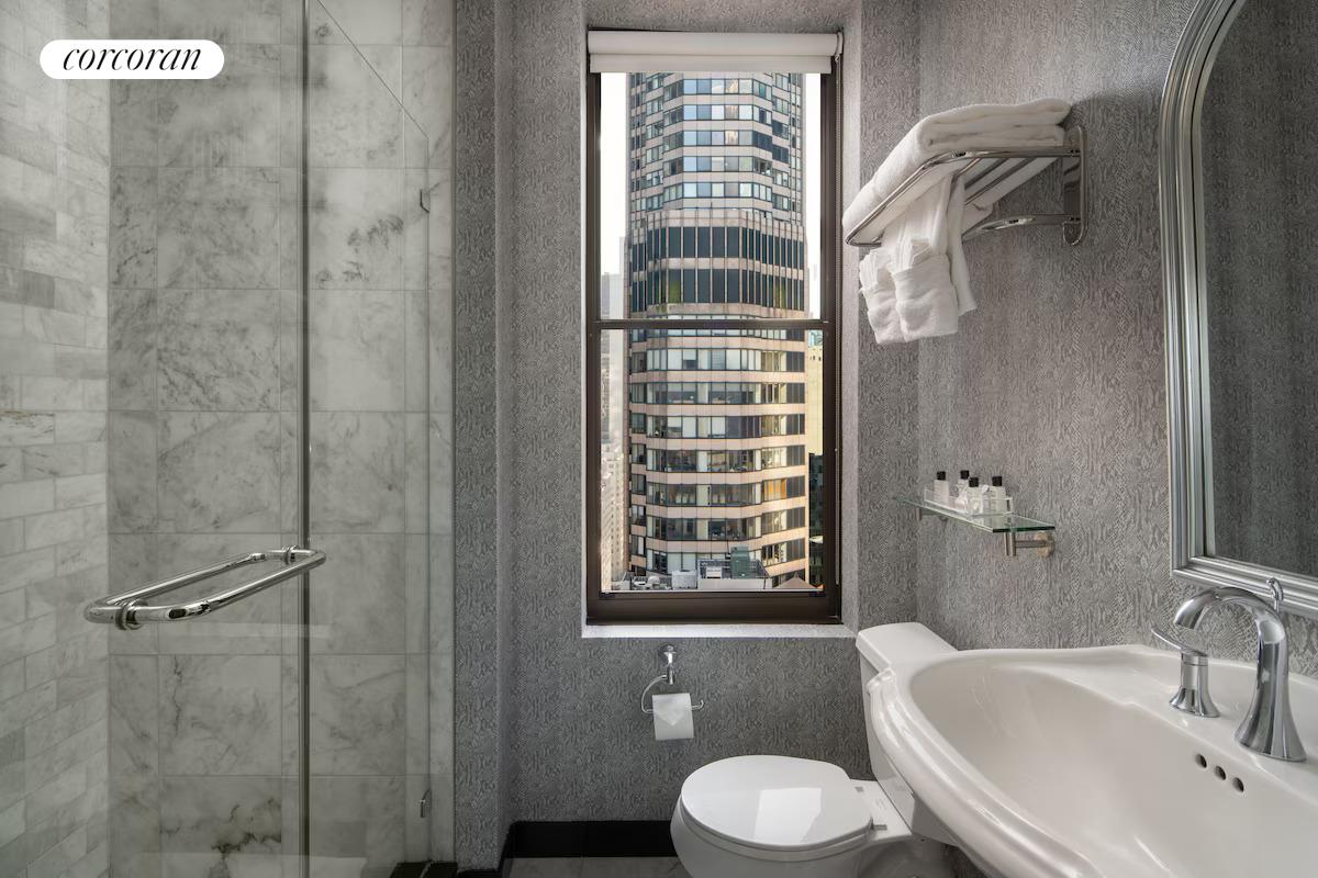 200 West 56th Street, Unit 904 Manhattan, NY 10019 - Photo 4 of 15 a bathroom with a sink toilet and shower