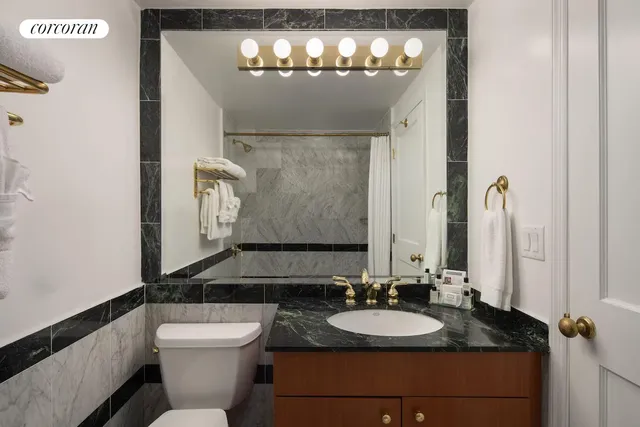 a bathroom with a toilet sink and mirror