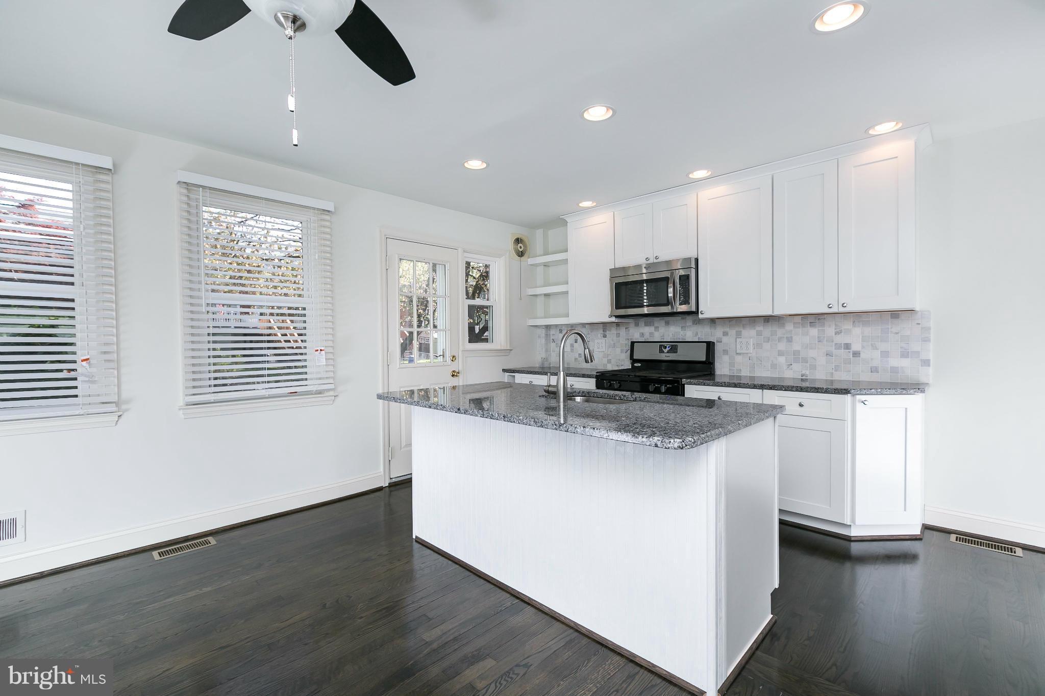 1636 Aberdeen Road Baltimore, MD 21286 - Photo 8 of 30 a kitchen with stainless steel appliances granite countertop a stove top oven a sink a window and white cabinets