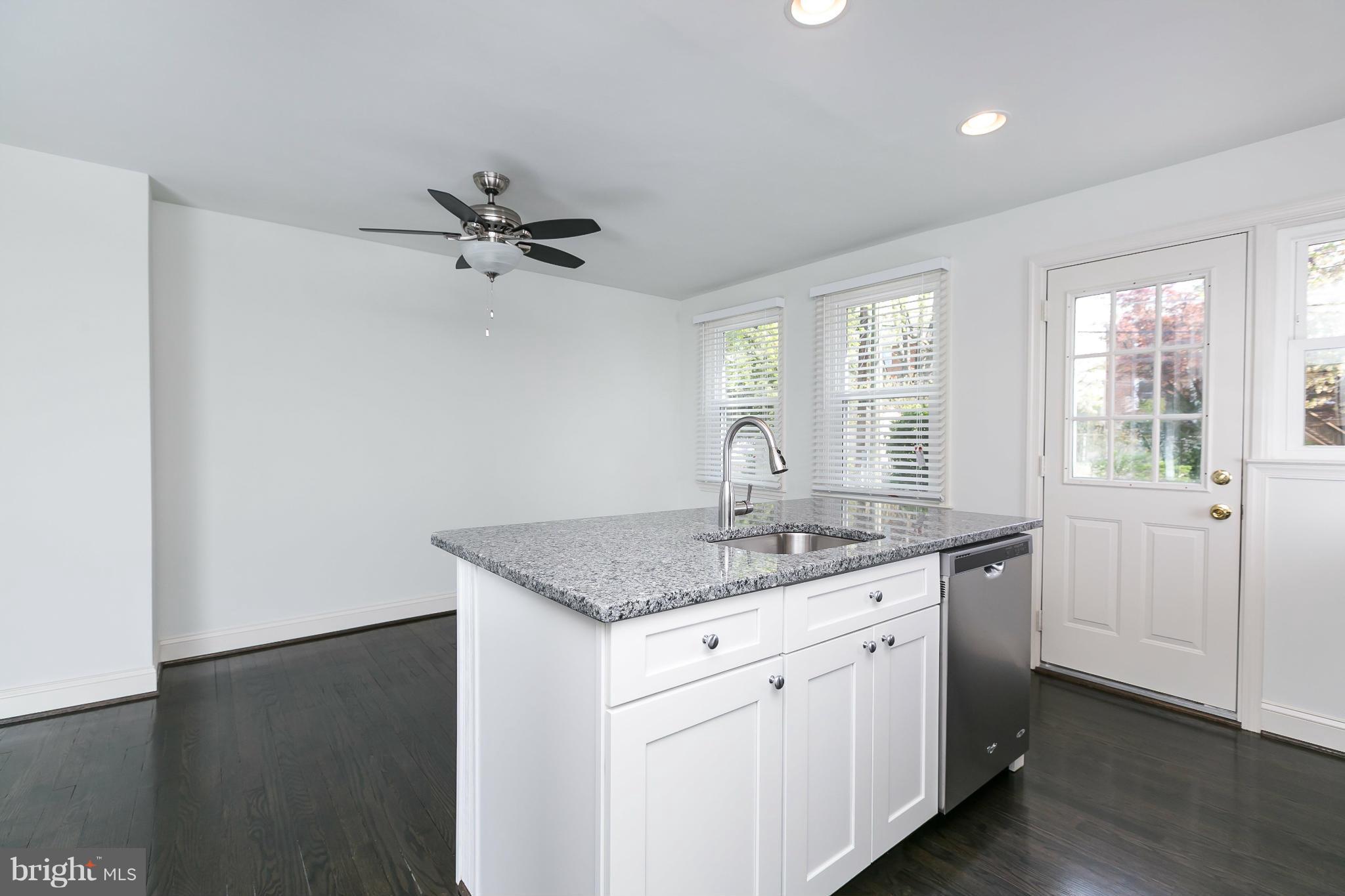 1636 Aberdeen Road Baltimore, MD 21286 - Photo 10 of 30 a kitchen with a sink dishwasher and white cabinets with wooden floor
