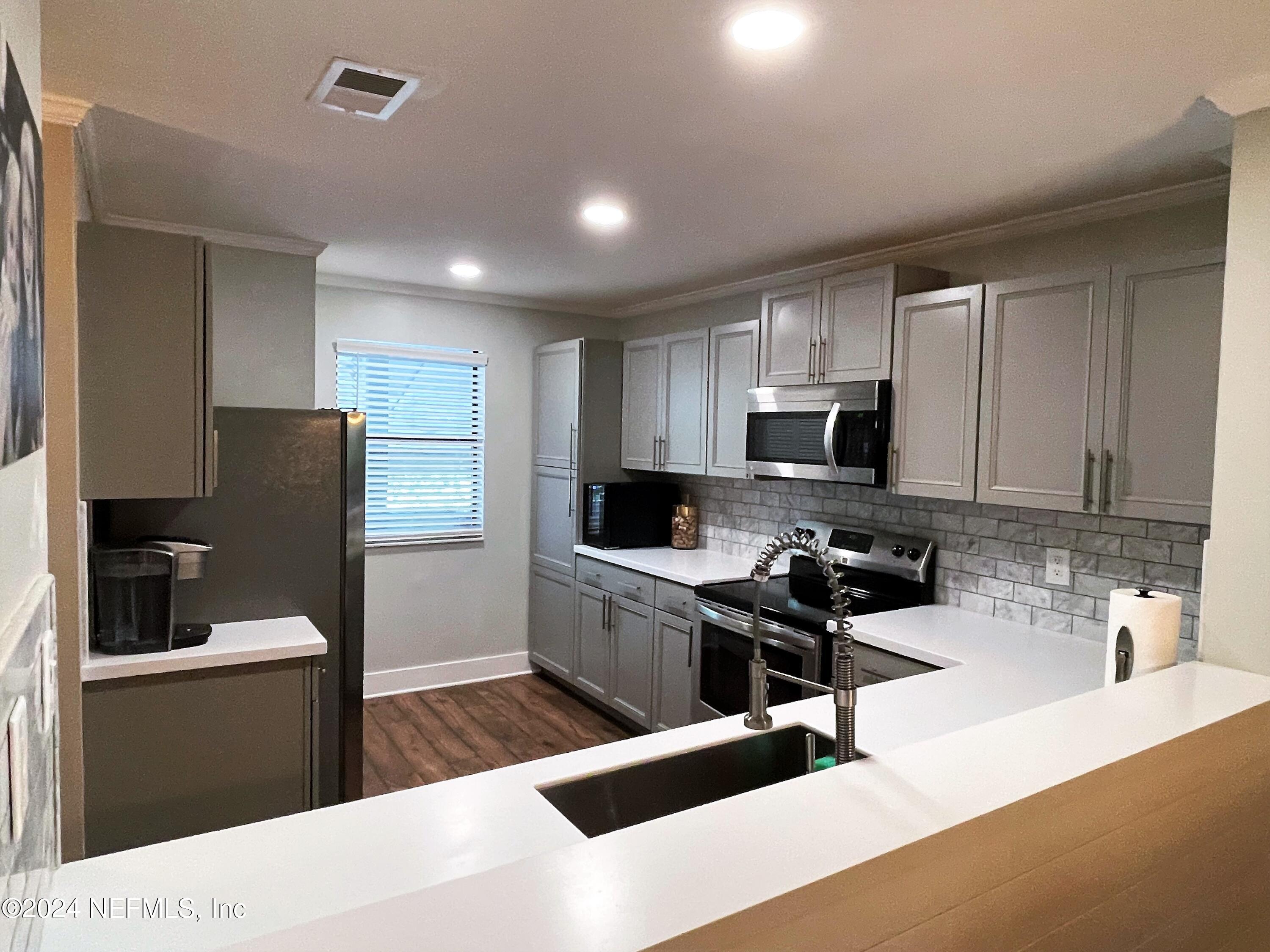 a kitchen with stainless steel appliances kitchen island granite countertop a refrigerator stove top oven and sink