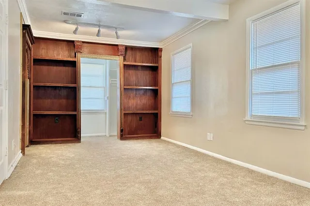 an empty room with a window and a fan