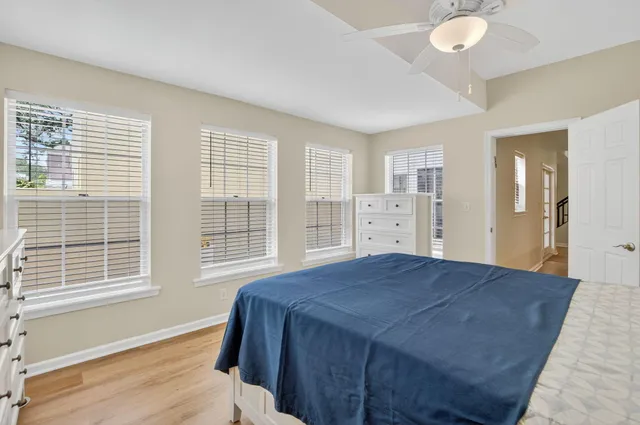 a view of a room with wooden floor a chandelier and windows