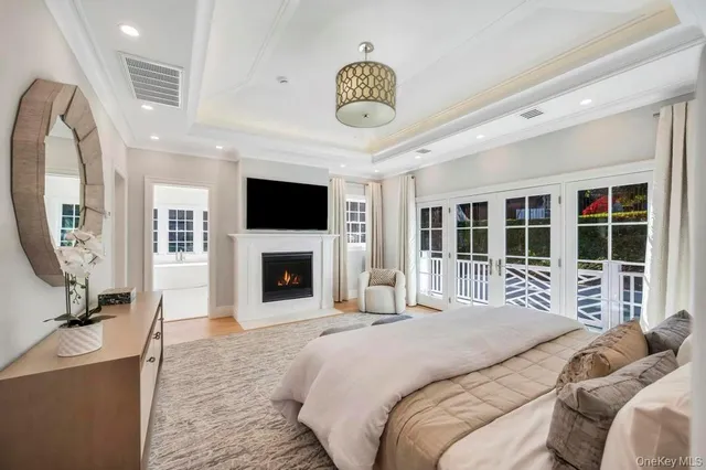 a bedroom with a bed a mirror and a large window