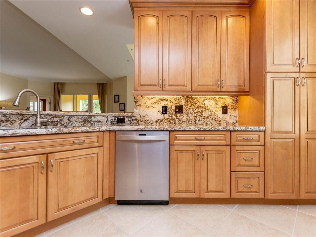 16101 Emerald Estates Drive, Unit 252 Weston, FL 33331 - Photo 5 of 51 a kitchen with granite countertop white cabinets and white appliances