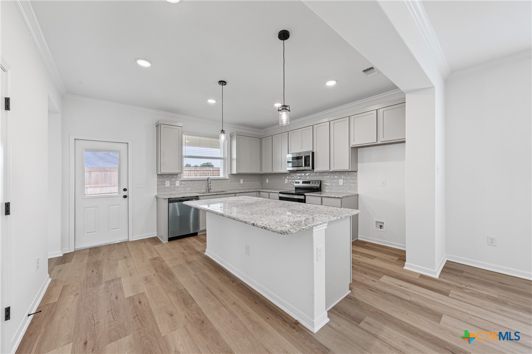 8019 Pineridge Way Temple, TX 76502 - Photo 13 of 32 a kitchen with stainless steel appliances granite countertop a sink a stove a refrigerator and island with wooden floor