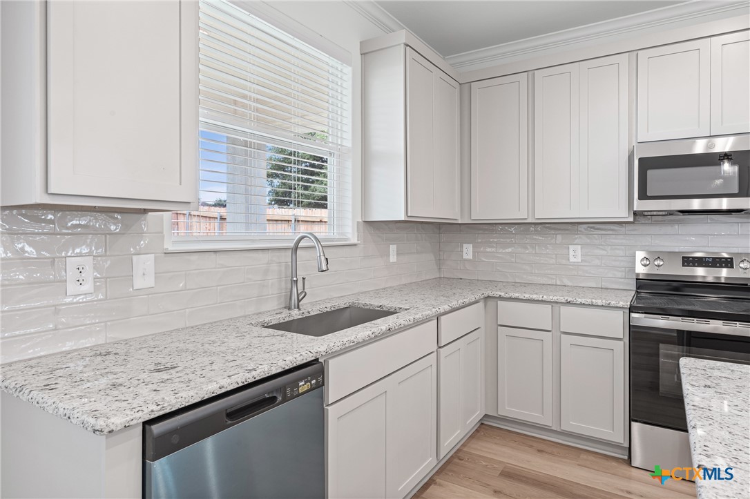 8019 Pineridge Way Temple, TX 76502 - Photo 16 of 32 a kitchen with granite countertop a sink and a stove