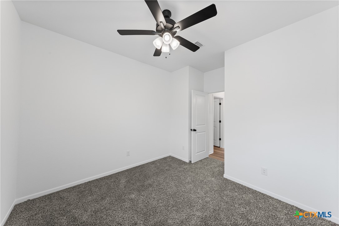 8019 Pineridge Way Temple, TX 76502 - Photo 23 of 32 an empty room with a chandelier fan and a ceiling fan