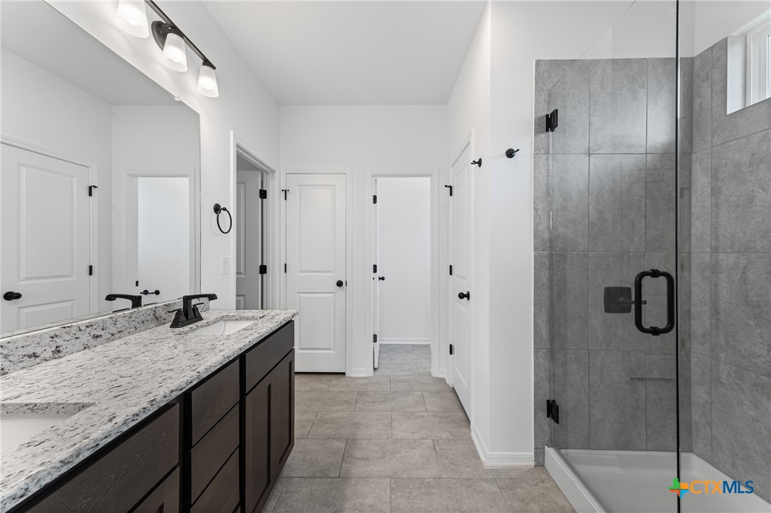 8019 Pineridge Way Temple, TX 76502 - Photo 26 of 32 a bathroom with a granite countertop double vanity sink and mirror
