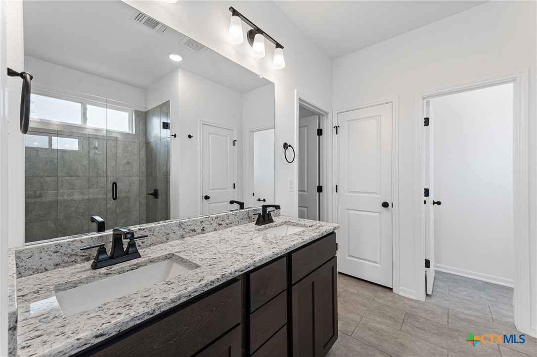 8019 Pineridge Way Temple, TX 76502 - Photo 27 of 32 a bathroom with a granite countertop sink and a mirror