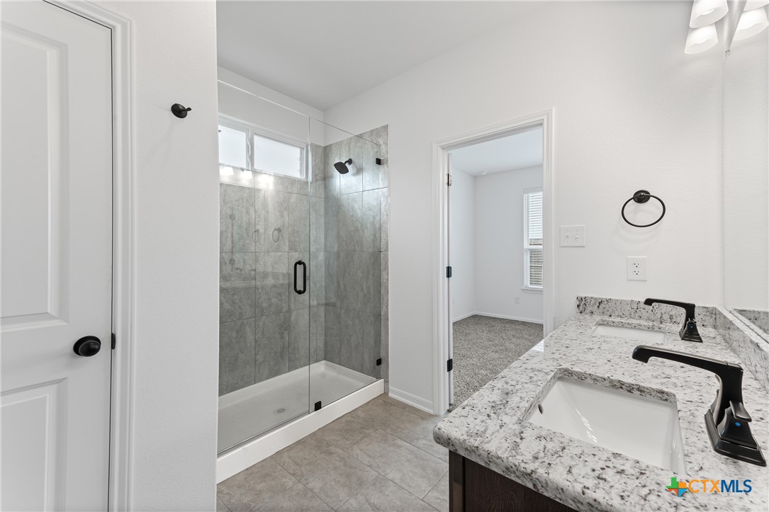 8019 Pineridge Way Temple, TX 76502 - Photo 28 of 32 a bathroom with a granite countertop tub sink and shower