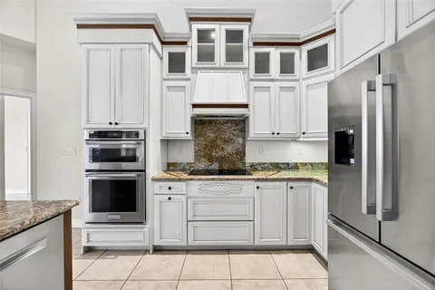 a kitchen with granite countertop a refrigerator and a sink