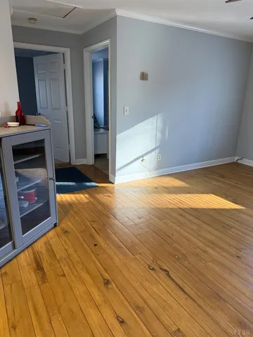 a view of a livingroom with wooden floor and a fireplace