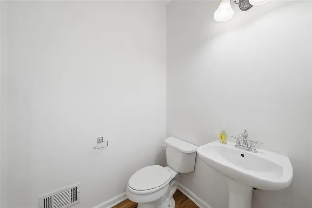 a view of an empty room with wooden floor fireplace and a window