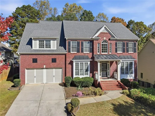 a aerial view of a brick house many windows and yard