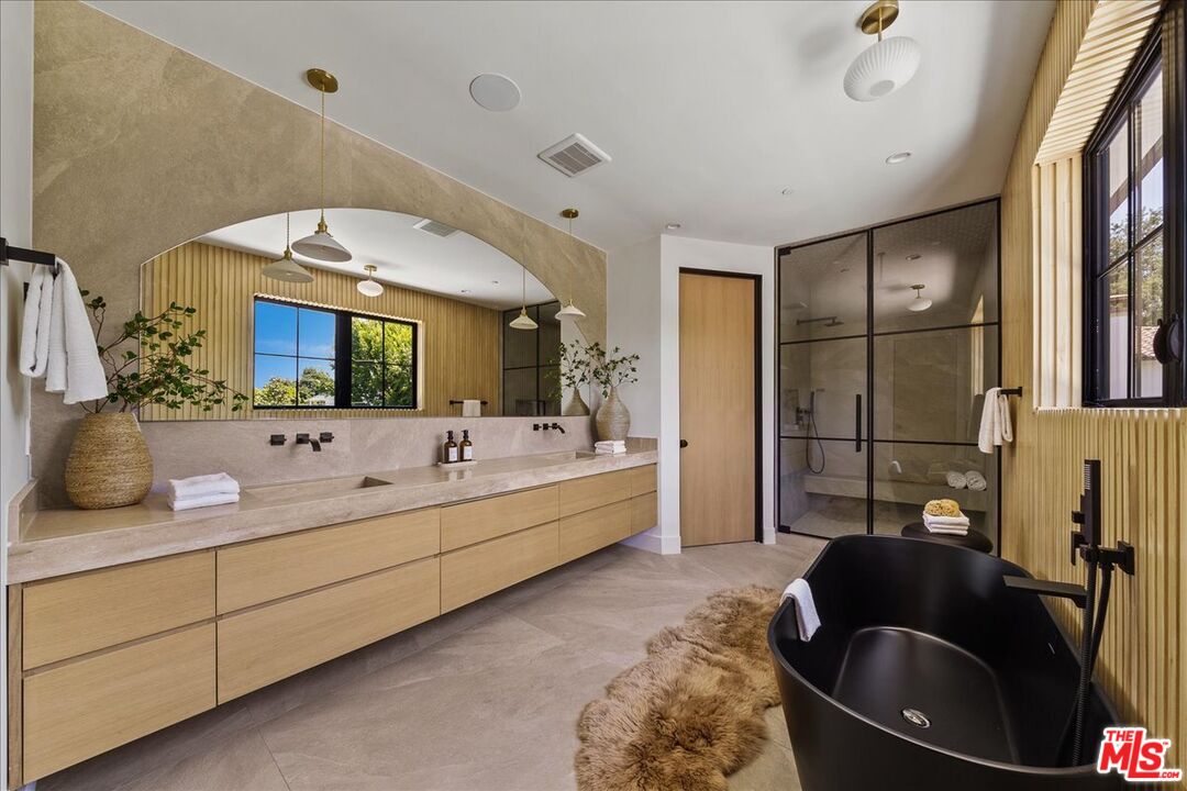 11317 Valley Spring Lane Studio City, CA 91602 - Photo 21 of 40 a spacious bathroom with a double vanity sink a mirror and a bathtub