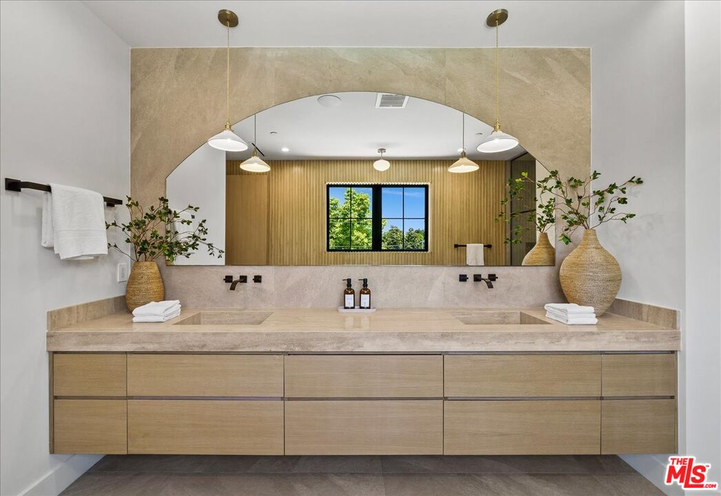 11317 Valley Spring Lane Studio City, CA 91602 - Photo 23 of 40 a bathroom with a granite countertop sink and a mirror