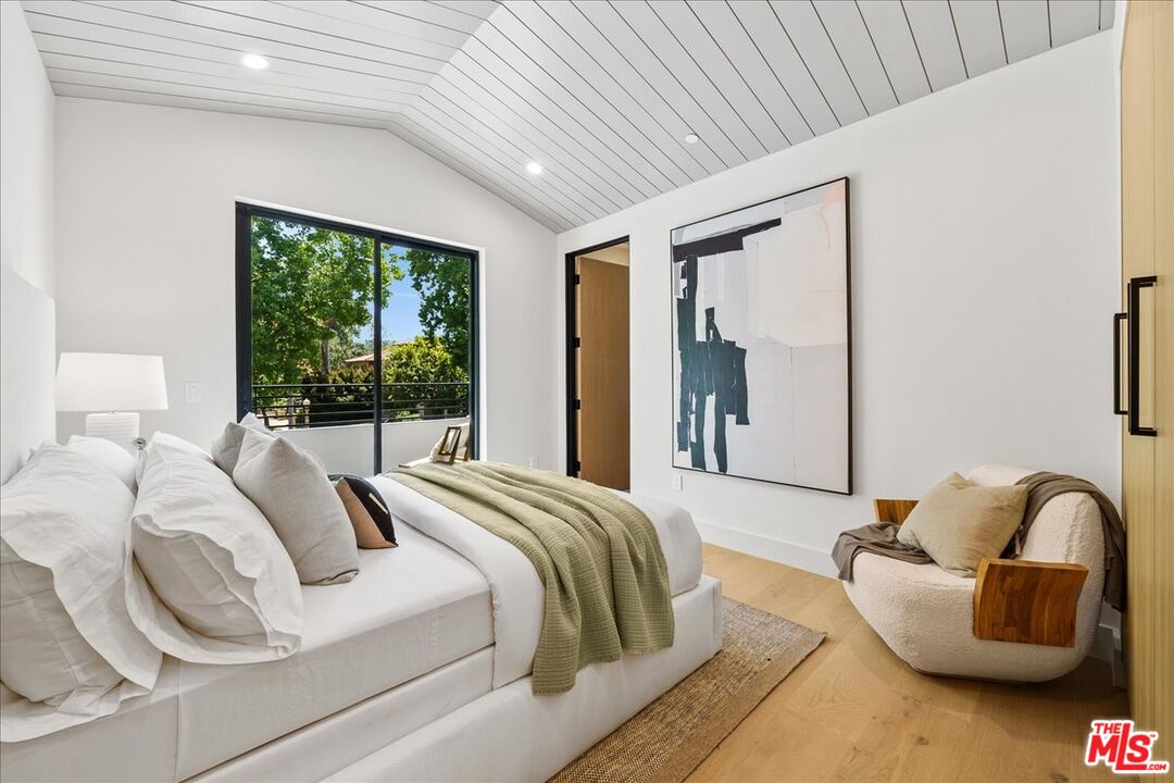 11317 Valley Spring Lane Studio City, CA 91602 - Photo 26 of 40 a bedroom with bed and a large window