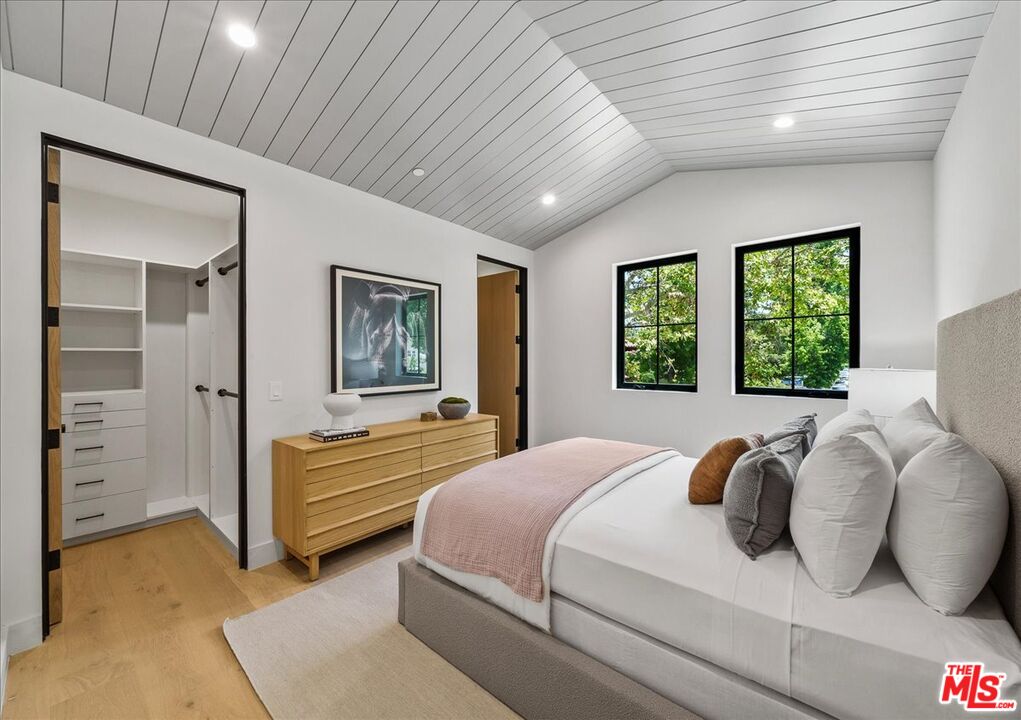 11317 Valley Spring Lane Studio City, CA 91602 - Photo 28 of 40 a bedroom with a bed and a chandelier