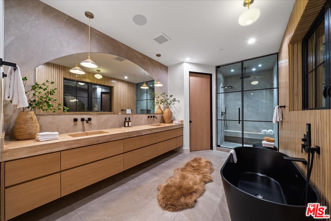 11317 Valley Spring Lane Studio City, CA 91602 - Photo 7 of 40 a large bathroom with a double vanity sink a mirror and a bathtub