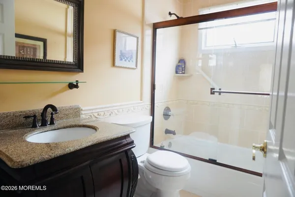 a bathroom with a granite countertop sink toilet and shower