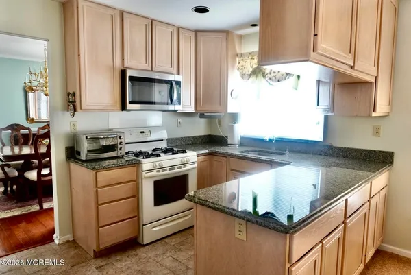 a kitchen with stainless steel appliances granite countertop a sink stove and microwave
