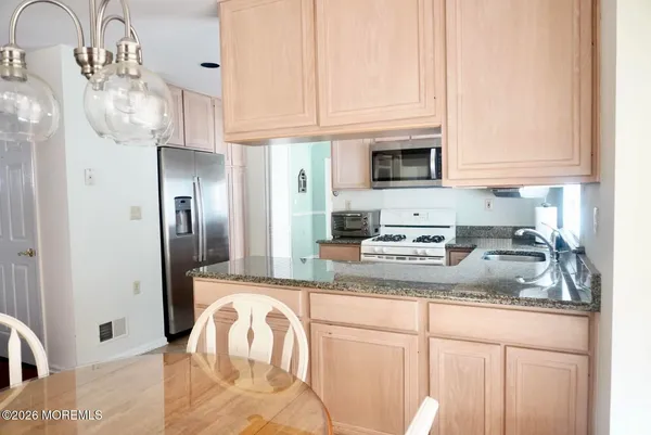 a kitchen with stainless steel appliances granite countertop a sink a refrigerator and a granite counter tops