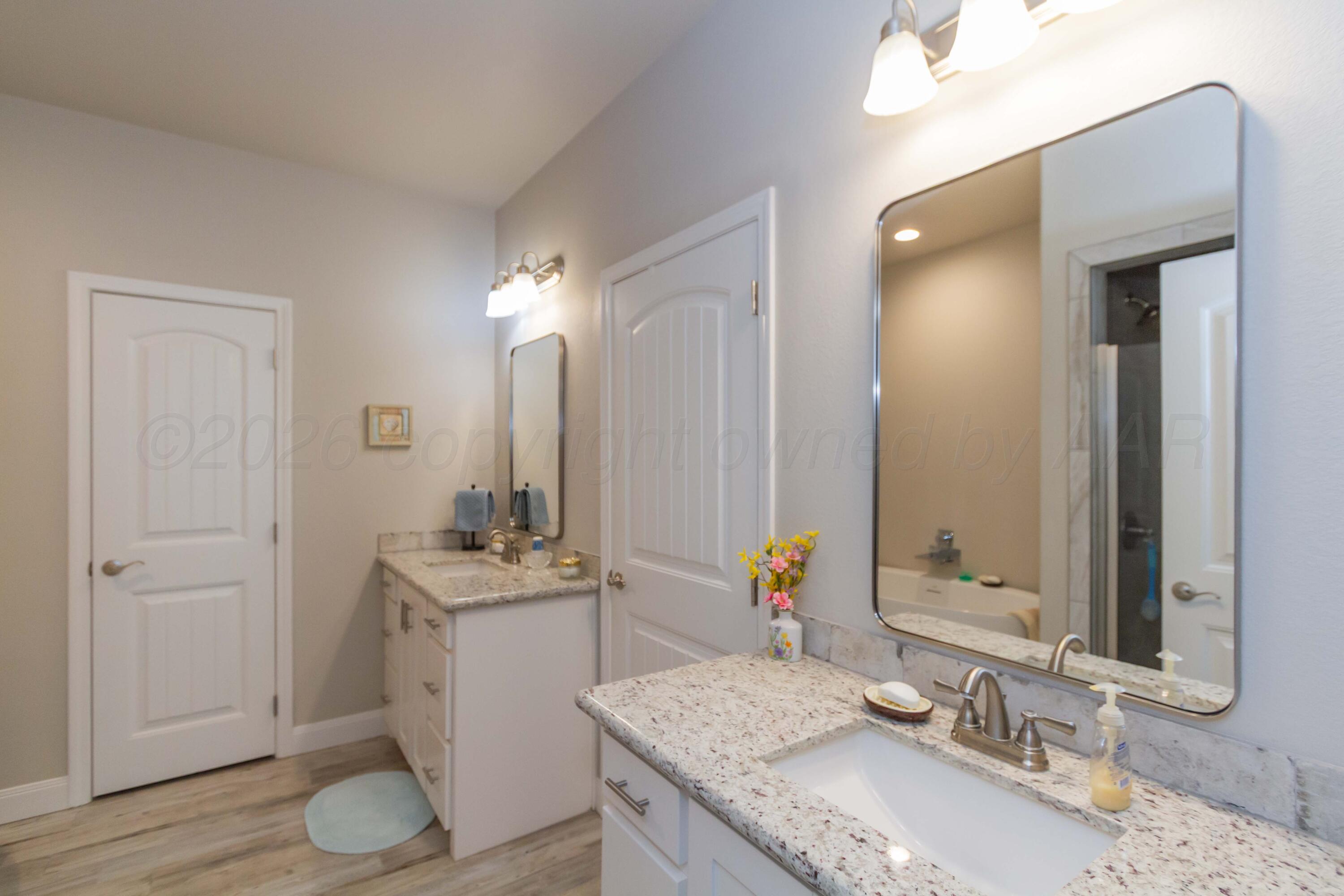 6909 Tatum Circle Amarillo, TX 79119 - Photo 14 of 33 a bathroom with a granite countertop sink and a mirror