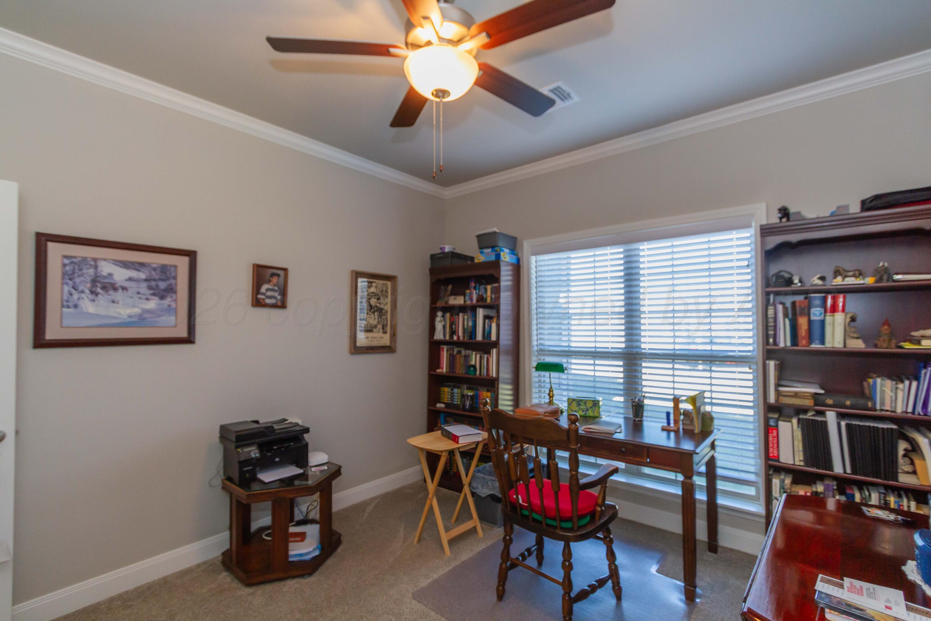 6909 Tatum Circle Amarillo, TX 79119 - Photo 22 of 33 a living room with furniture a bookshelf and a window