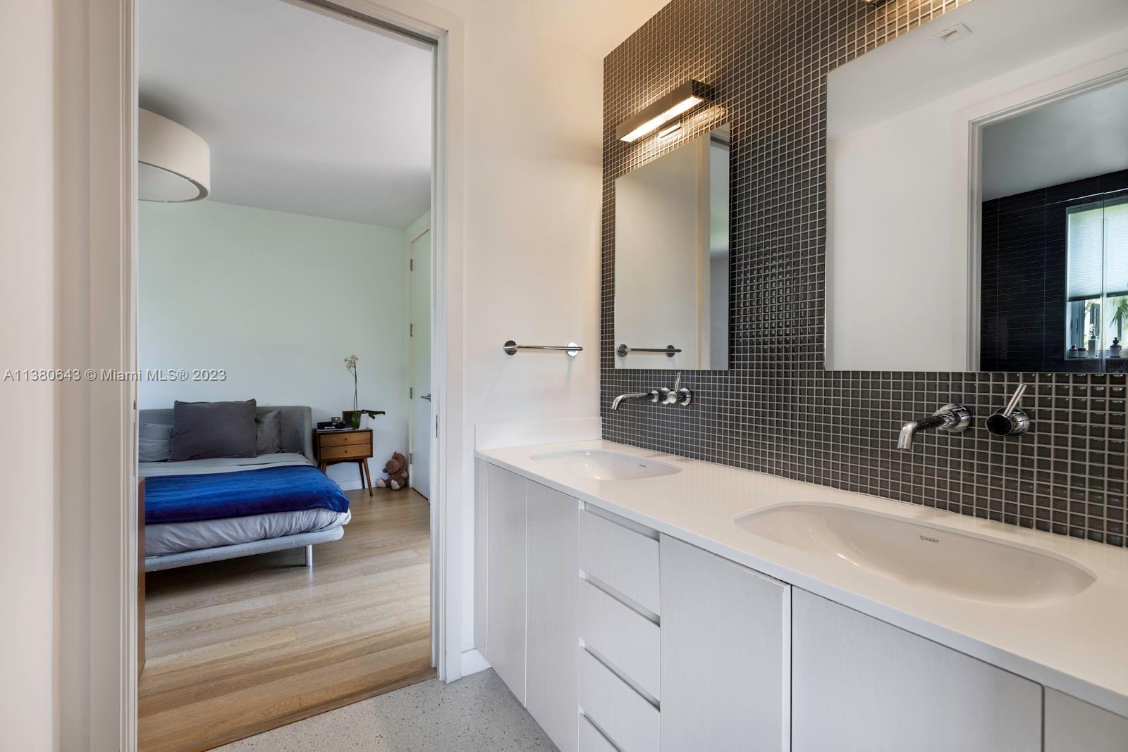 380 Woodcrest Road Key Biscayne, FL 33149 - Photo 15 of 31 a en suite bathroom with a double vanity sink and a mirror