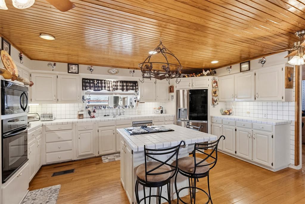 304 Scarlett Road Weatherford, TX 76087 - Photo 22 of 32 a kitchen with a table chairs and white cabinets