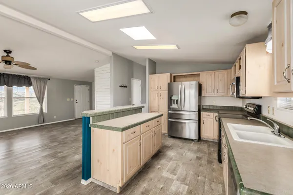 a kitchen with stainless steel appliances granite countertop a stove a sink and a microwave