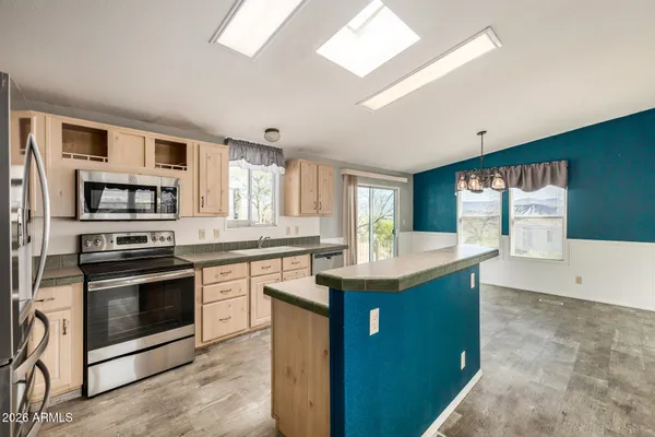 a kitchen with granite countertop a refrigerator stove top oven and sink