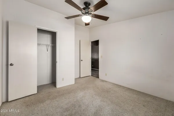an empty room with a window and a fan
