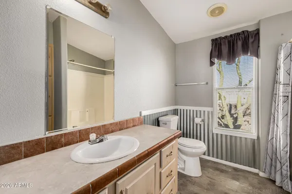 a bathroom with a tub shower vanity and a sink