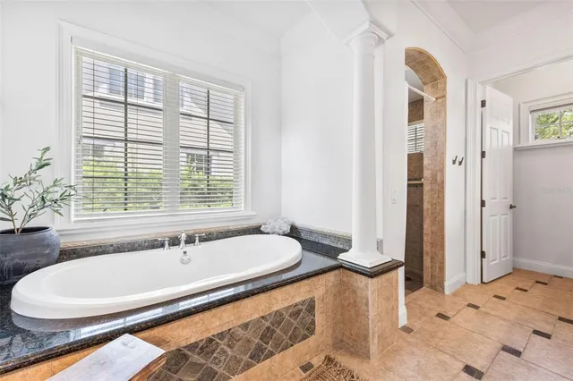 a bathroom with a granite countertop tub and a sink