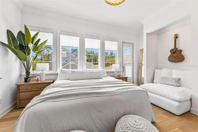 a bedroom with a bed a couch and a large window