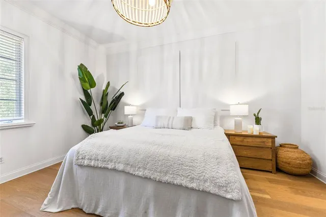 a bedroom with a bed and a potted plant