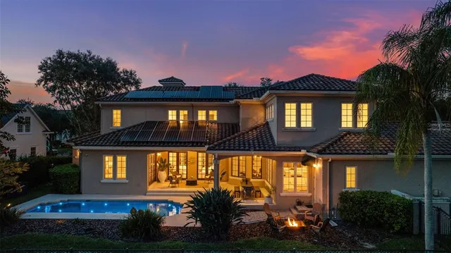 a view of a house with a large tree and a yard in front of it